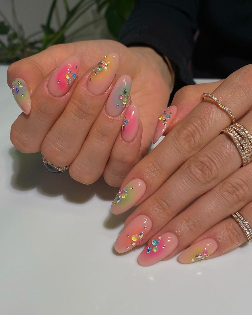 A pair of hands showing off jelly, almond-shaped aura nails
