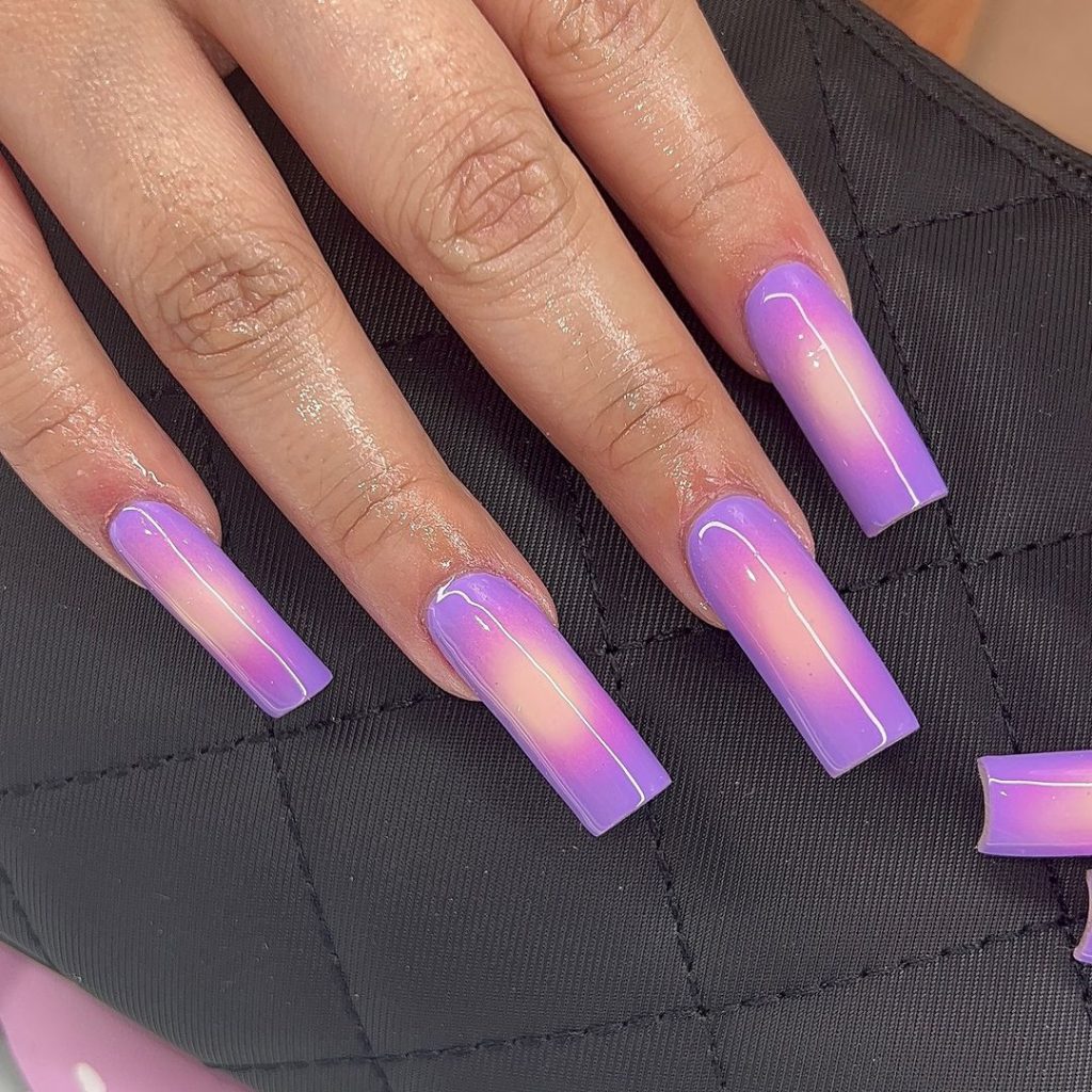 A pair of hands showing off stylish, long aura nails