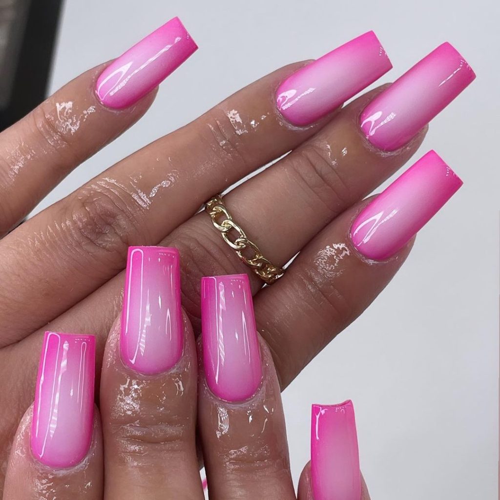 A pair of hands showing off hot pink, medium aura nails