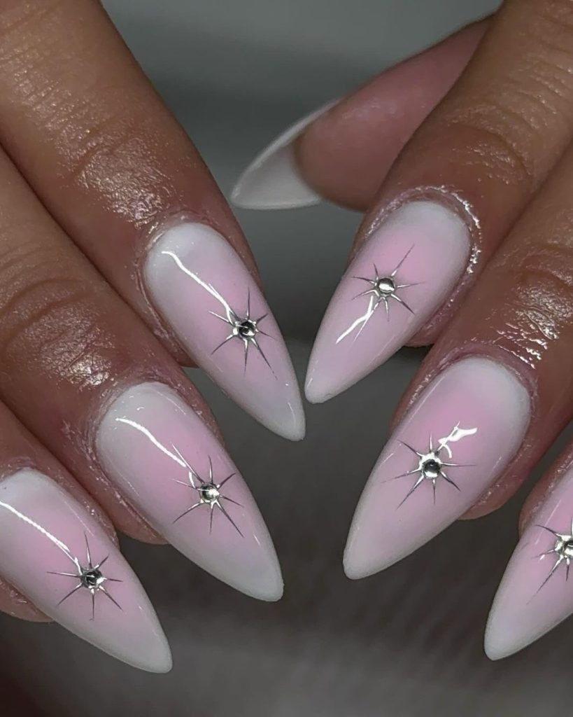 A pair of hands showing off pink, almond-shaped aura nails
