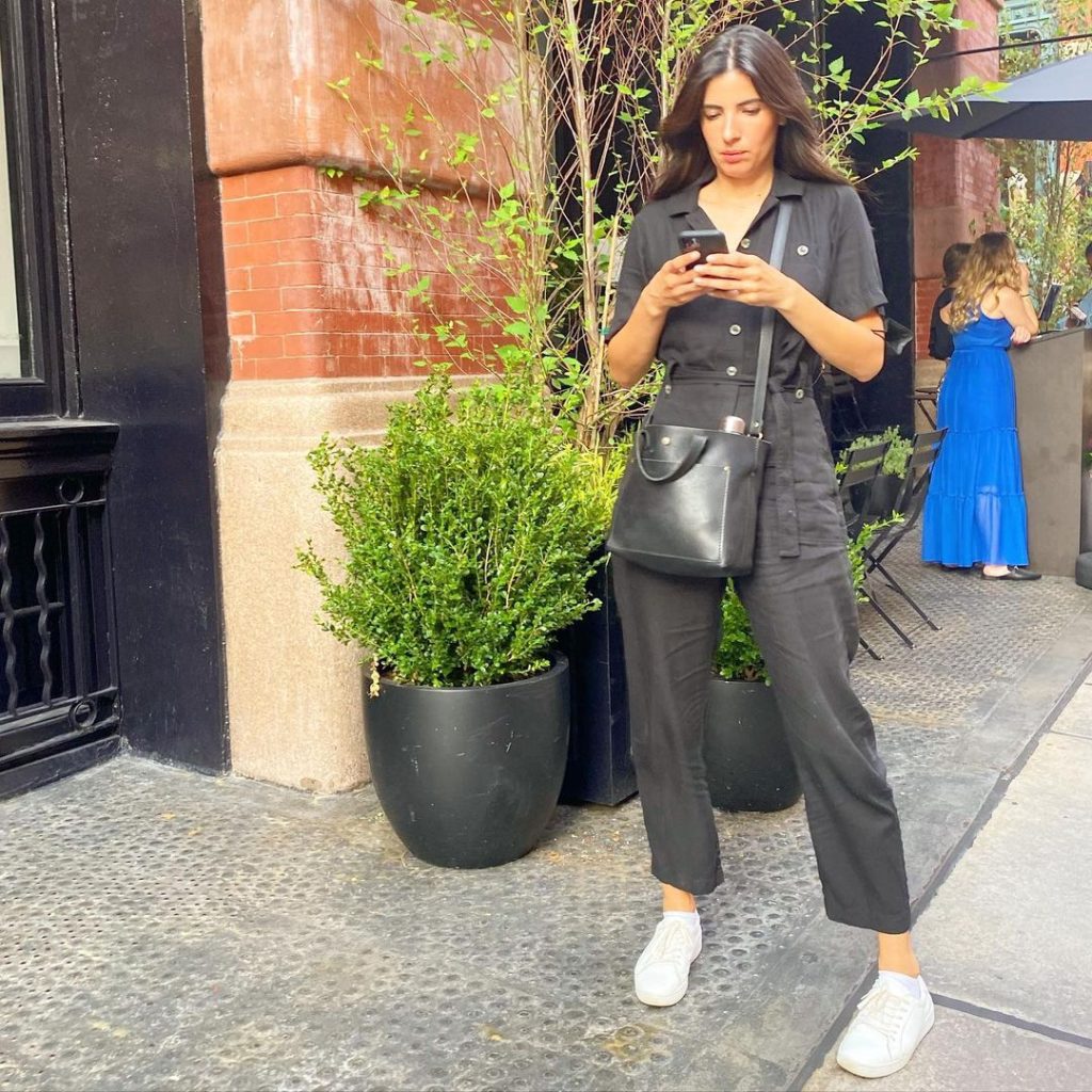 black jumpsuit paired with white sneakers